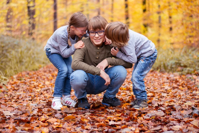 Familienfotografie von drei Geschwistern im Wald
