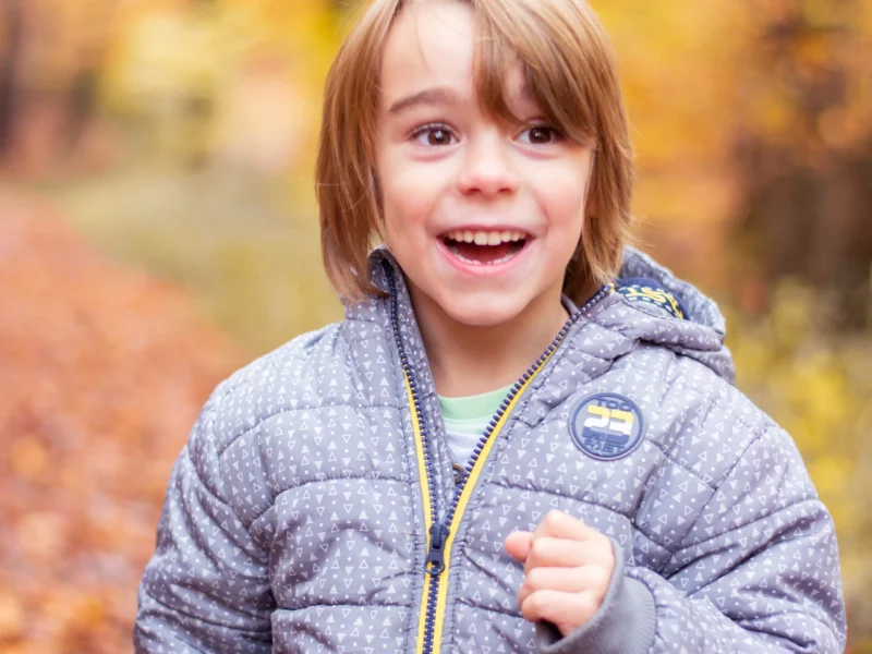 lachender Junge beim spielen im Wald - Kitafotografie
